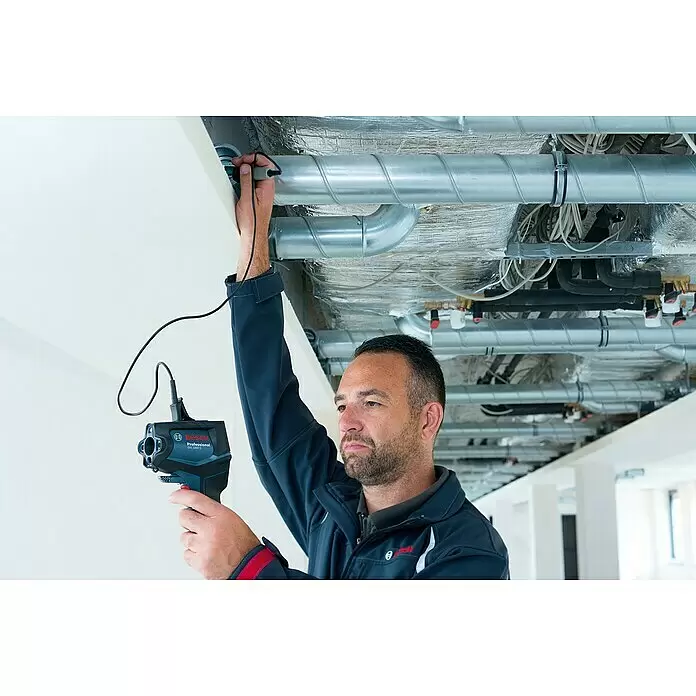 Bosch Professional Thermodetektor GIS 1000 C - 1 Akku, Messbereich Temperatur: -40 °C - 1.000 °C - Mann verwendet eine blau-schwarze Bosch Professional Wärmebildkamera mit Sonde zur Inspektion von Deckenrohren.