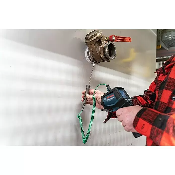 Bosch Professional Thermodetektor GIS 1000 C - 1 Akku, Messbereich Temperatur: -40 °C - 1.000 °C - Eine Person misst die Temperatur einer Messingarmatur an einer Wand mit einer blauen Bosch Wärmebildkamera und einer grünen Sonde.
