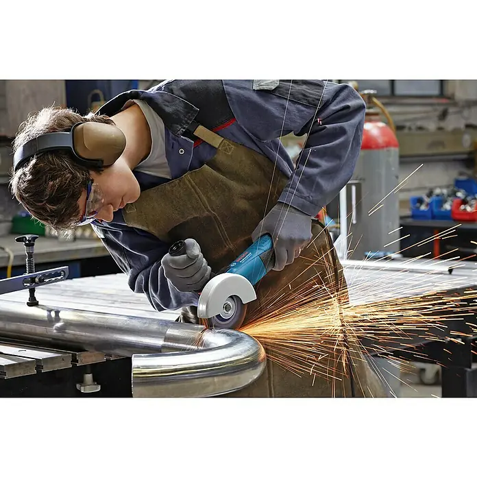 Bosch Professional Elektro-Winkelschleifer GWS 17-125 S - 1.700 W, Durchmesser Scheibe: 125 mm, Leerlaufdrehzahl: 2.800 U/min - 11.500 U/min - Ein Mann, der eine Rohrbiegemaschine mit einer Bosch-Schleifmaschine bearbeitet, wobei Funken sprühen, während er Schutzausrüstung trägt.