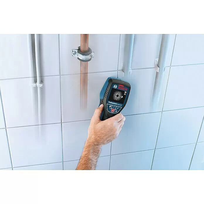 Bosch Professional Ortungsgerät D-tect 120 - 1 Akku, Erfassungstiefe: Max. 38 mm Holzunterkonstruktionen - Hand hält blauen und schwarzen Bosch D-tect 120 Wandscanner an Fliesenwand, erfasst versteckte Rohre und Leitungen.