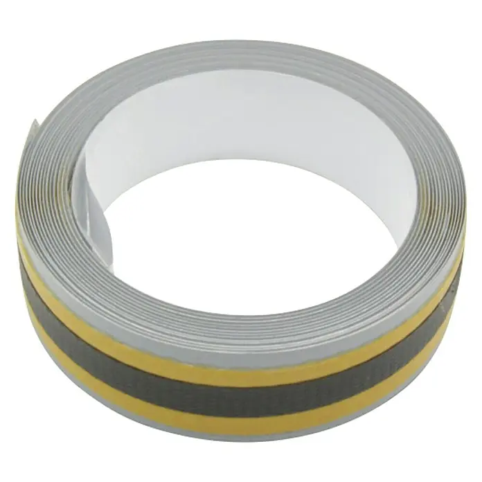 Häfele Metallband - L x B: 2.000 x 35 mm - Nahaufnahme einer Rolle grauen Kantenumleimers mit schwarzem und goldenem Streifen auf schwarzem Hintergrund.