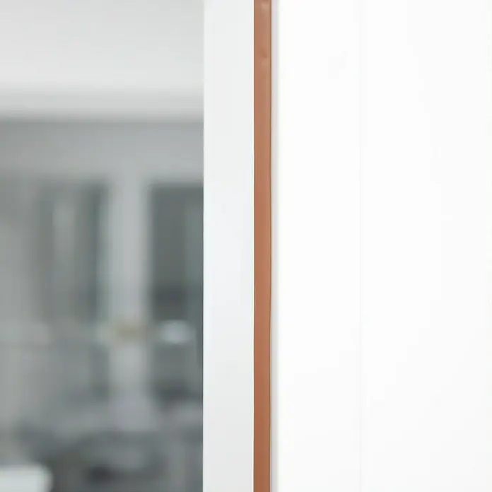 Primo Universaldichtung Densa 25 - Braun, 6 m, Passend für: Fenster, Türen, Möbel mit Spaltenbreite 2 – 5 mm - Nahaufnahme einer eleganten Tür mit einem schlanken, braunen Ledergriff, der einen modernen Touch verleiht. Helle, neutrale Farbpalette für minimalistisches Design.