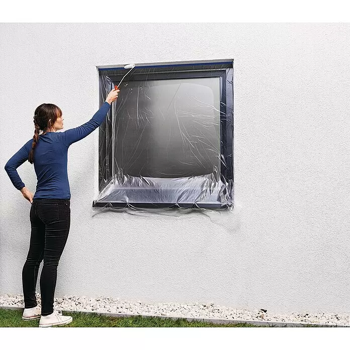 Tesa Abdeckfolie Easy Cover Outdoor - L x B: 20 m x 140 cm - Person malt mit einem Eck-Farbroller mit rotem Griff präzise entlang einer abgeklebten Fensterkante.