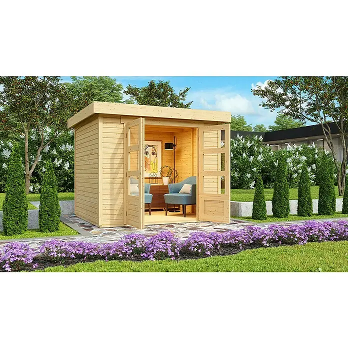 Karibu Gartenhaus Askola - Außenmaß inkl. Dachüberstand (B x T): 266 x 238 cm, Holz, Natur - Hölzernes Gartenhaus mit weit geöffneten Türen, umgeben von üppiger Vegetation und lila Blumen. Der Innenraum ist gemütlich eingerichtet.