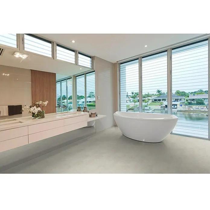 Star Clic Vinylboden - Assisi, Fliese, 605 x 304,8 x 5 mm - Elegantes Badezimmer mit freistehender Badewanne vor großen Fenstern, die einen Blick auf den Kanal bieten. Die Badewanne ist das Highlight des Raumes.
