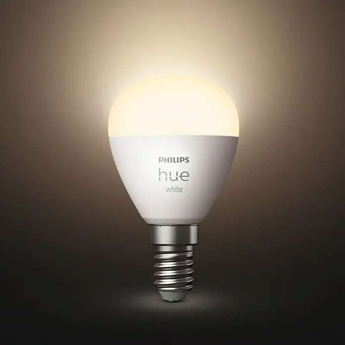 Philips Hue Smart-LED-Lampen Set Tropfenform E14 matt - E14, Dimmbar, Warmweiß, 470 lm, 5,7 W, Tropfen, 1 Stk. - Nahaufnahme einer Philips Hue White Glühbirne, die ein warmes, einladendes Licht ausstrahlt und moderne Technologie mit klassischem Design verbindet.