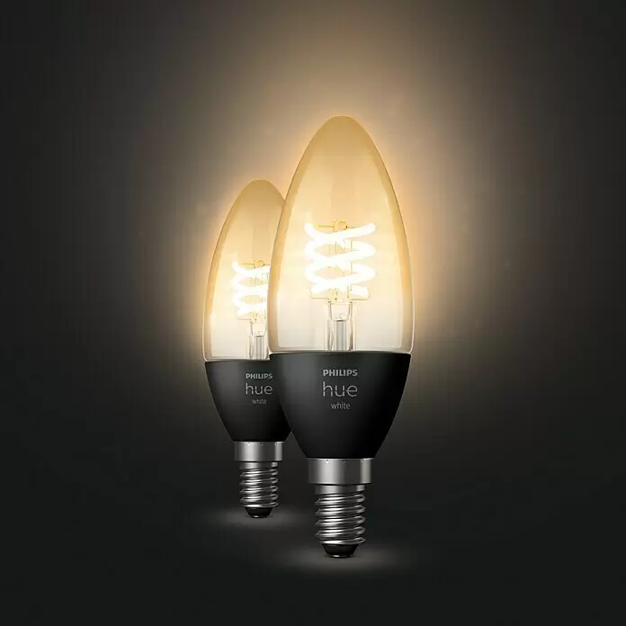 Philips Hue Smart-LED-Lampen Set Smart Vintage E27 - E14, Dimmbar, Warmweiß, 300 lm, 4,5 W, 2 Stk. - Zwei Philips Hue Smart-LED-Kerzenlampen mit schwarzem Sockel und leuchtenden warmweißen Wendelfilamenten.