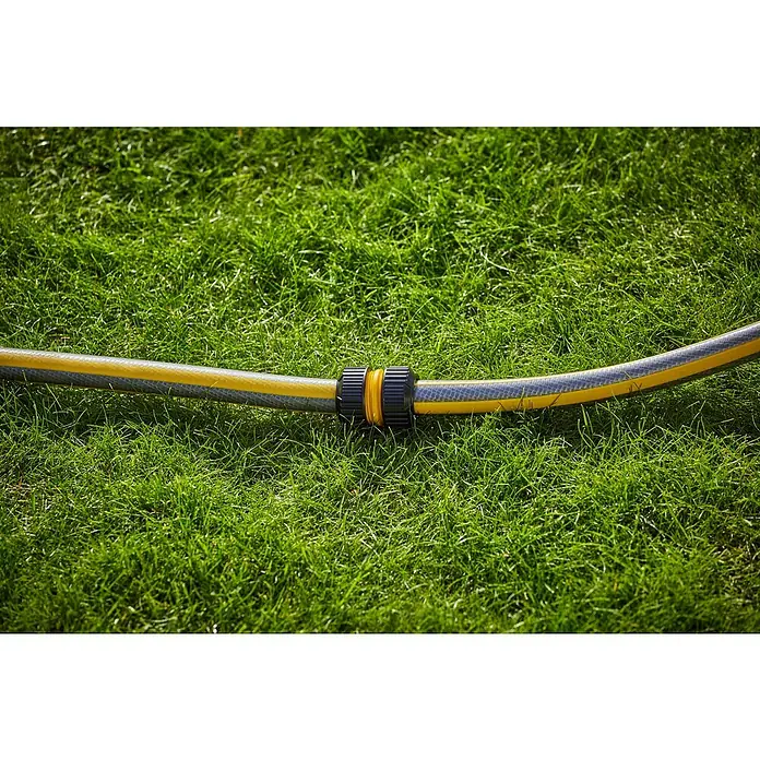 Neptun Universal-Reparaturstück - ¾″ - Nahaufnahme eines gelb-grauen Gartenschlauchs mit Verbinder auf einem grünen Rasen, ideal für die Gartenbewässerung.