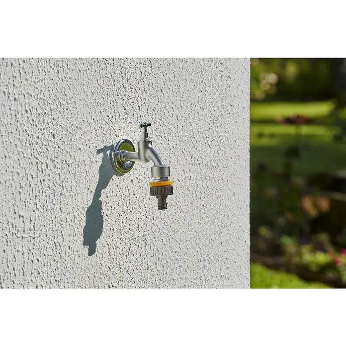Neptun Hahnverbinder - 33,3 mm (1″), 26,5 mm (¾″), 21 mm (½″) - Nahaufnahme eines Wasserhahns mit Anschlussstück an einer Wand. Ideal für Gartenbewässerung und Außenbereich.