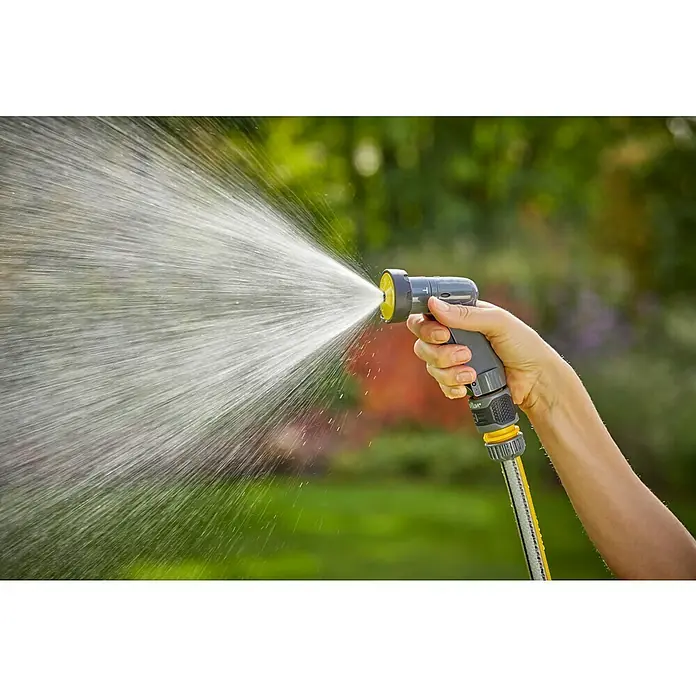 Neptun Bewässerungsbrause Kompakt - Anzahl Sprühformen: 4 Stk., Kunststoff - Eine Hand hält einen Gartenschlauch, aus dem Wasser in einem Garten spritzt. Der Sprühkopf ist gelb.