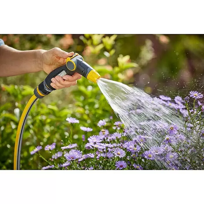 Neptun Brause - Kunststoff - Hand hält gelb-schwarze Gartenspritze und Schlauch, bewässert lila Blumen im Garten.
