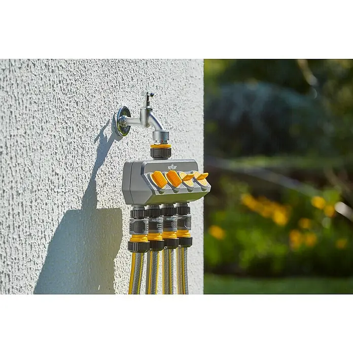 Neptun 4-Wege-Verteiler - Gewindegröße Wasserhahn: 33,3 mm (1″), 26,5 mm (¾″), 21 mm (½″) - Ein Vierwege-Wasserhahnverteiler von NEPTUN ist an einer Außenwand montiert und angeschlossen, um mehrere Gartenschläuche gleichzeitig zu versorgen.