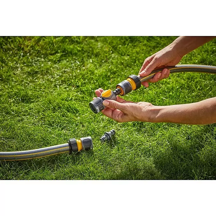 Neptun Regulierventil - ½″ - Hände verbinden einen grau-gelben Gartenschlauch mit Schnellkupplungen, eine davon mit 'OFF'-Hebel.