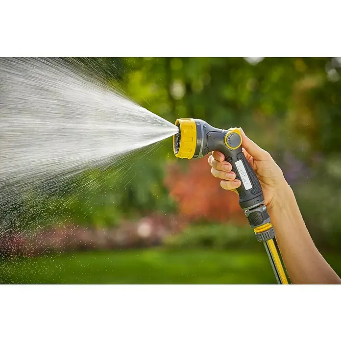 Neptun Bewässerungsbrause - Anzahl Sprühformen: 7 Stk. - Nahaufnahme einer Hand, die einen gelben/grauen Gartenschlauch mit sprühendem Wasser hält, ideal für die Gartenarbeit.