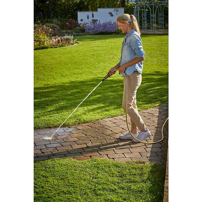 Neptun Reinigungsspritze - Kunststoff - Eine Frau reinigt eine Terrasse mit einem Gartenschlauch. Der Wasserschlauch ist gelb und wird von der Frau bedient, um Schmutz zu entfernen.