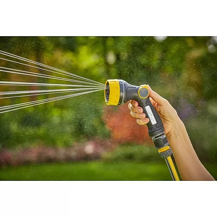 Neptun Bewässerungsbrause - Anzahl Sprühformen: 7 Stk. - Hand hält gelb-schwarze Gartenschlauchdüse, die Wasser in einen Garten sprüht.