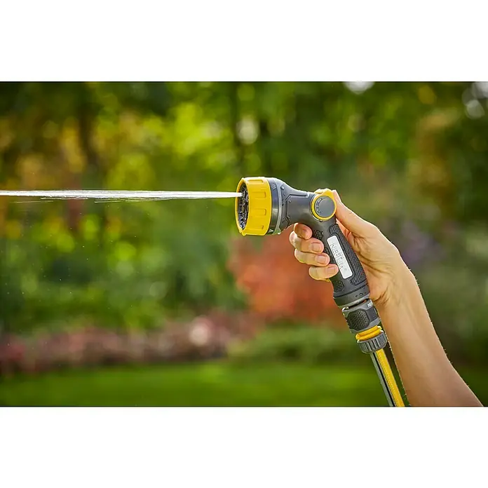 Neptun Bewässerungsbrause - Anzahl Sprühformen: 7 Stk. - Nahaufnahme einer Hand, die eine gelb-graue Gartenspritze hält, aus der Wasser strömt, vor einem verschwommenen Hintergrund im Freien.