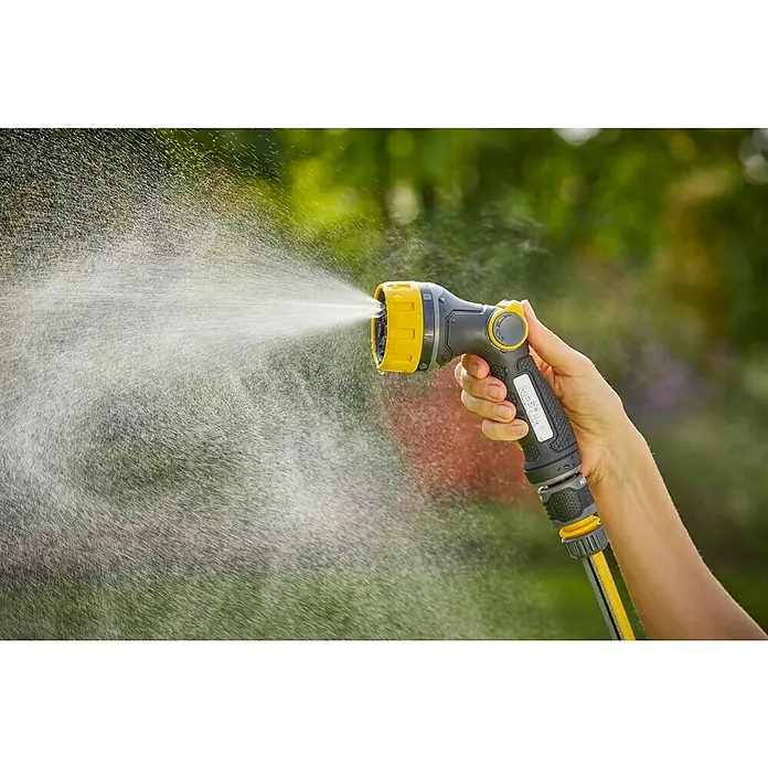 Neptun Bewässerungsbrause - Anzahl Sprühformen: 7 Stk. - Nahaufnahme eines gelb-grauen Gartenschlauchs im Einsatz, der Wasser versprüht, mit grünem Hintergrund.
