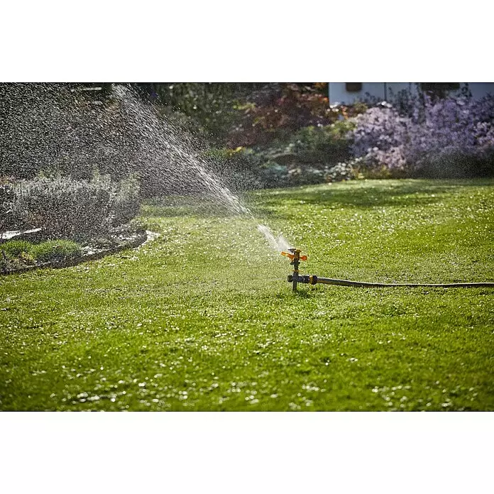 Neptun Kreisregner - Kunststoff, Max. Regnerfläche: 410 m² - Gelb-grauer Gartensprenger bewässert einen grünen Rasen mit sichtbaren Wassertropfen.