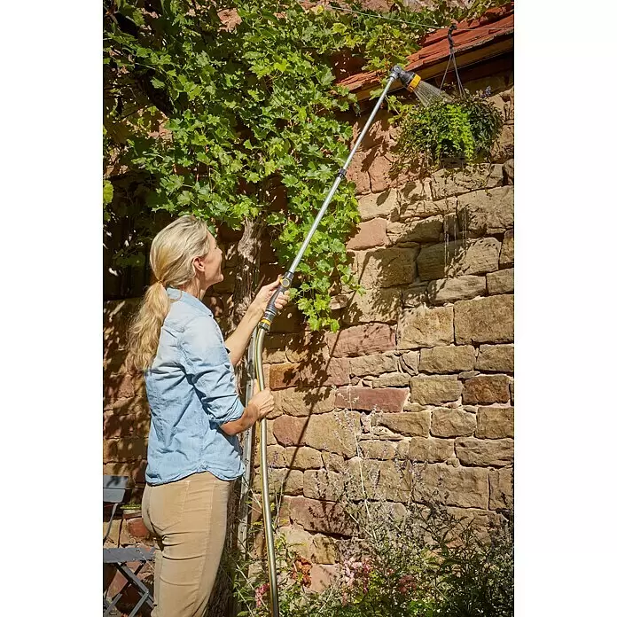 Neptun Teleskop-Gießstab - Länge: 84 cm, Aluminium/Kunststoff - Eine Frau bewässert eine Hängepflanze mit einer langen, grau-gelben Gießbrause und demonstriert deren Reichweite.
