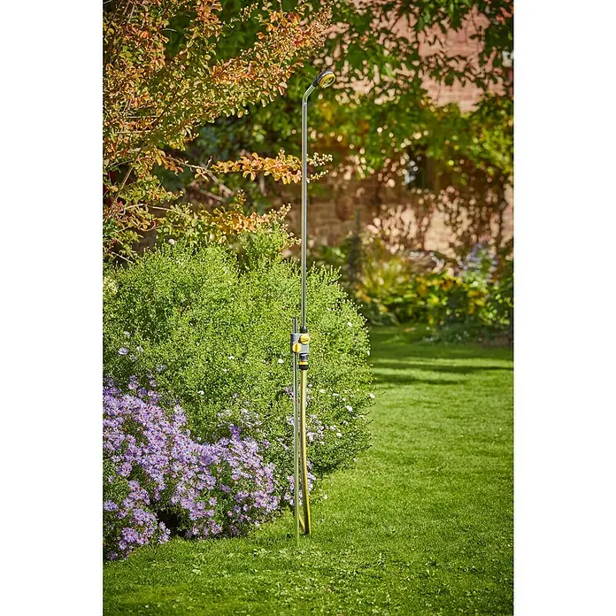 Neptun Gartendusche - 117 cm, Dreibeinstativ, Aluminium - Gartendusche aus Chromstahl mit gelbem Schlauchanschluss und Duschkopf im Grünen.