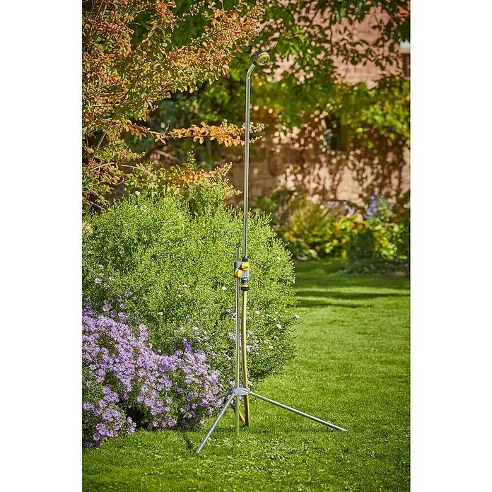 Neptun Gartendusche - 117 cm, Dreibeinstativ, Aluminium - Bild von einer Gartenbrause mit Stativ auf einem Rasen vor Büschen und Bäumen.