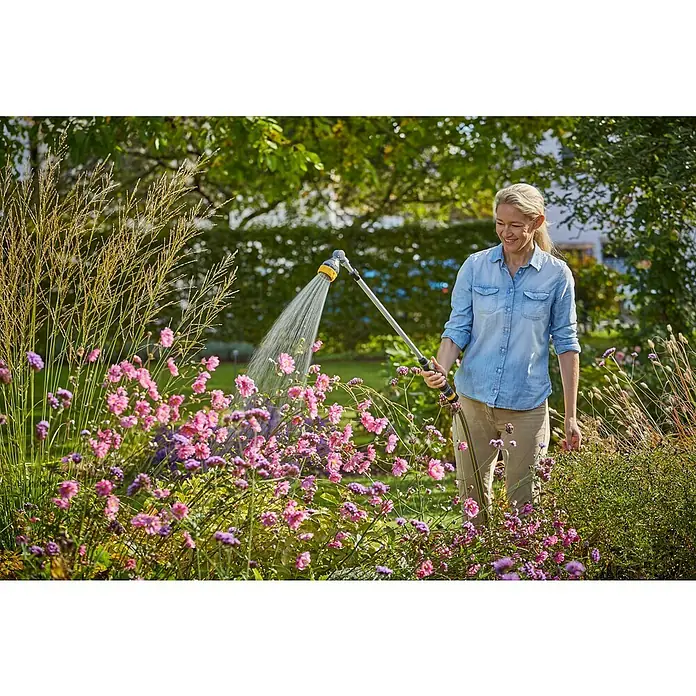 Neptun Teleskop-Gießstab - Länge: 84 cm, Aluminium/Kunststoff - Frau gießt Blumen mit einem GARDENA Regner, der durch seinen langen Griff ideal für eine komfortable Gartenarbeit ist.