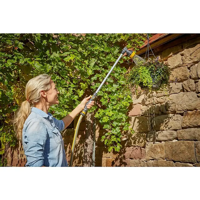Neptun Gießstab - Länge: 76 cm, Aluminium/Kunststoff - Frau bewässert eine Hängepflanze mit einem GARDENA Regner. Der Regner ist an einem gelben Schlauch befestigt und ermöglicht bequemes Gießen.