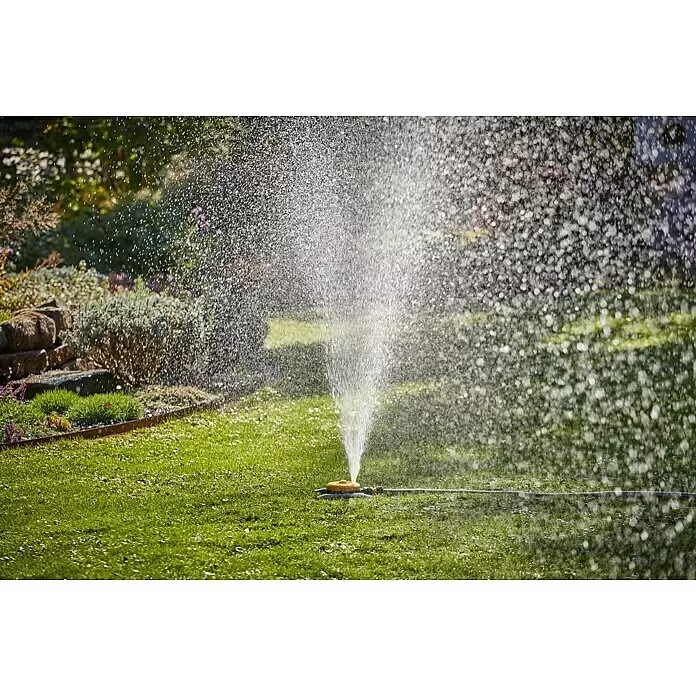 Neptun Vielflächenregner - Kunststoff - Ein gelb-schwarzer Gartensprenger bewässert einen grünen Rasen.