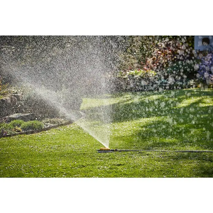 Neptun Vielflächenregner - Kunststoff - Der Rasensprenger bewässert den Rasen an einem sonnigen Tag und sorgt für eine üppige grüne Fläche. Ein Gartenaccessoire für die Bewässerung.