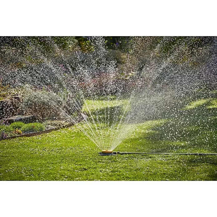 Neptun Vielflächenregner - Kunststoff - Gelber und grauer Gartensprenger bewässert aktiv einen grünen Rasen und Gartenbeete.