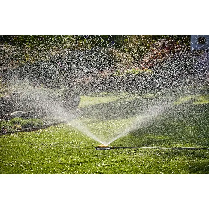 Neptun Vielflächenregner - Kunststoff - Rasensprenger bewässert einen grünen Rasen mit spritzendem Wasser, ideal für die Gartenpflege und Bewässerung.