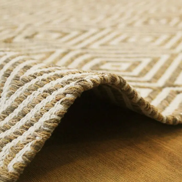 Kayoom Flachgewebeteppich Cocktail 300 - Beige/Braun, 170 x 120 cm, 100% Baumwolle - Nahaufnahme eines beigen Teppichs mit geometrischem Muster, der eine gemütliche und stilvolle Atmosphäre ausstrahlt.