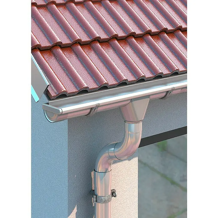 Sarei Rinnenstutzen - 100/80 mm, Zink/Titanzink, Silber - Nahaufnahme einer Dachrinne aus Metall mit roten Dachziegeln, die Wasser ableitet und das Gebäude vor Feuchtigkeit schützt.