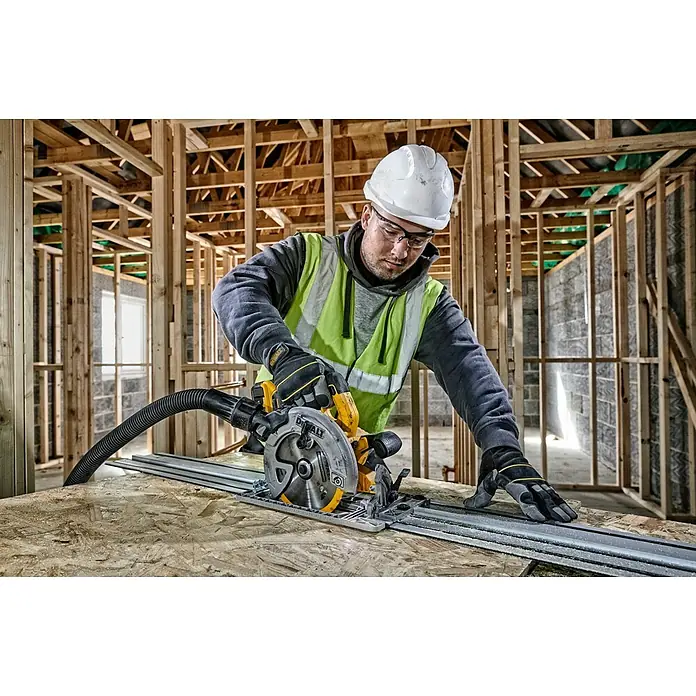DeWalt XR 18V Akku-Handkreissäge DCS572N-XJ - Ohne Akku, 0 U/min - 5.500 U/min - Ein Bauarbeiter mit Helm und Schutzbrille bedient eine DeWalt-Kreissäge mit Führungsschiene auf einer Baustelle.