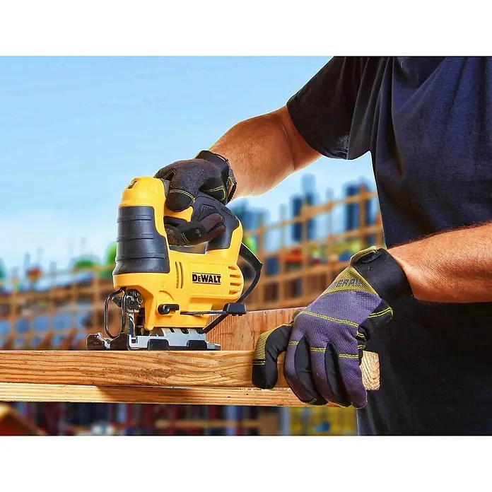DeWalt Elektro-Pendelhubstichsäge DWE349-QS - 500 /min - 3.200 /min, Max. Schnitttiefe in Holz: 85 mm, Anzahl Pendelhubstufen: 3 Stk. - Nahaufnahme einer gelben DEWALT Stichsäge im Einsatz, die Holz schneidet. Ein Arbeiter mit Handschuhen führt das Elektrowerkzeug präzise.