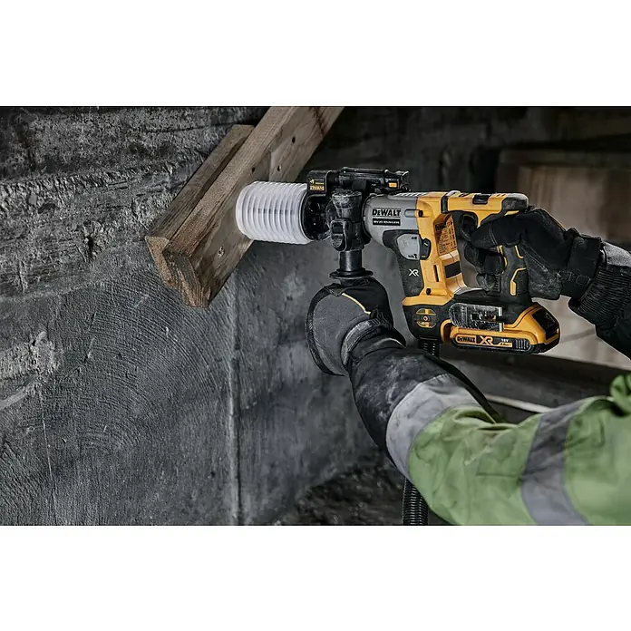 DeWalt XR 18V Akku-Bohrhammer DCH172N-XJ18 V, Ohne Akku, 1,4 J - Ein gelb-schwarzer DeWalt Akku-Bohrhammer wird benutzt, um in eine Wand zu bohren. Das Gerät verfügt über eine Staubabsaugung.