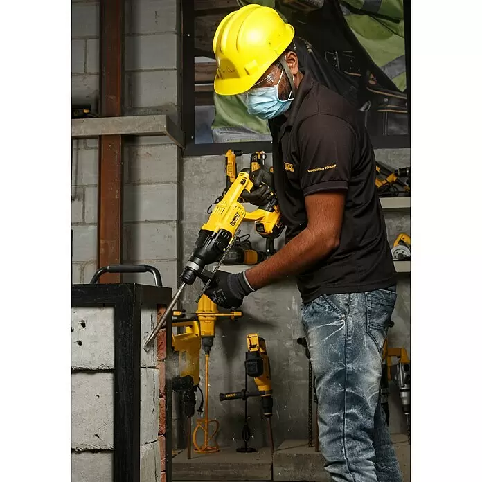 DeWalt XR 18V Akku-Kombihammer DCH133N-XJ - 18 V, Ohne Akku, 2,6 J - Gelber DeWalt Bohrhammer im Einsatz, bohrt in eine Ziegelwand.