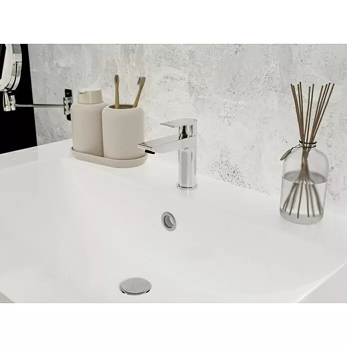 Camargue Waschtischarmatur Flat - Chrom, Glänzend - Moderne Badezimmerwaschbecken-Einrichtung mit Chromarmatur, beigem Spender-Set und Reed-Diffusor auf weißem Becken vor einer strukturierten Wand.