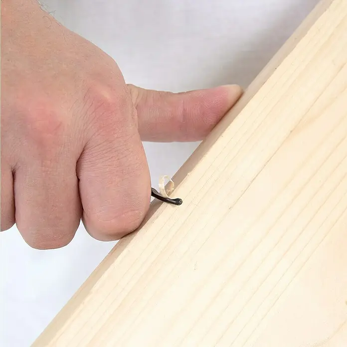 Wisent Entgrater - 12 -tlg., 360 ° drehbares Gehäuse - Nahaufnahme eines Holzes mit einer schwarzen Klammer und einem kleinen Holzspan, gehalten von einer Hand.