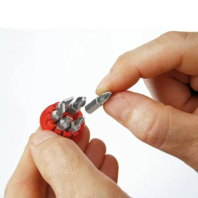Wiha Mini-Schraubendreher-Set Stubby - 7 -tlg., Geeignet für: TORX®-Schrauben - Hand entnimmt einen silbernen Schraubendreherbit aus rotem Rundhalter mit mehreren Bits.