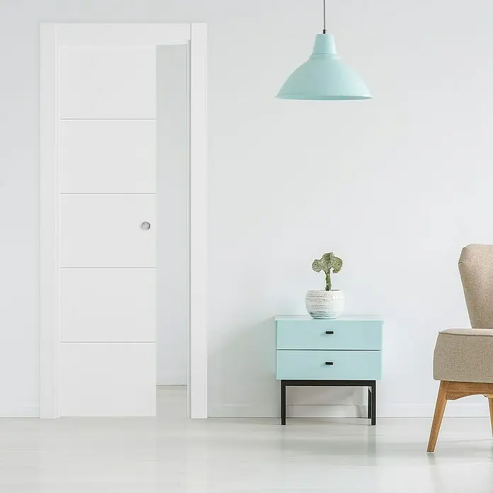 Puerta corredera de madera Recife - 72,5 x 203 cm, Blanco, Maciza, Con uñero - Habitación acogedora con una elegante puerta corredera blanca, una elegante mesita de noche azul y una lámpara colgante a juego.