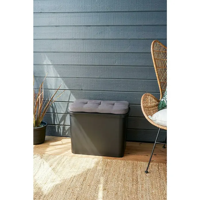 SmartStore Collect Deckel - 40 x 58,5 cm, Kunststoff, Schwarz - Ein grauer Outdoor-Hocker mit Sitzkissen steht auf einem Teppich, vor einer Wand. Neben dem Hocker steht eine Pflanze.