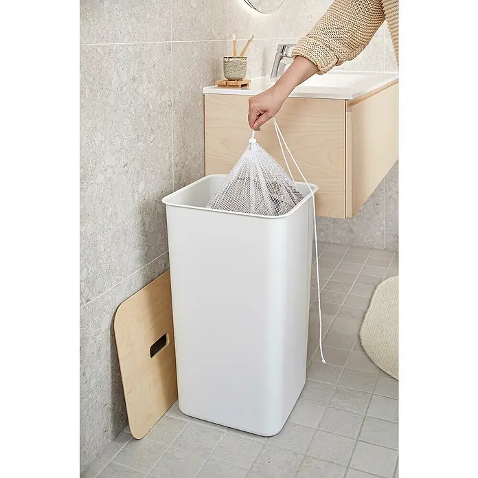 SmartStore Collect Netztasche - SmartStore Mülltrennsystem Collect - Ein weißer Wäschekorb aus Kunststoff mit einem hölzernen Deckel daneben, der sich perfekt für jedes Badezimmer eignet.
