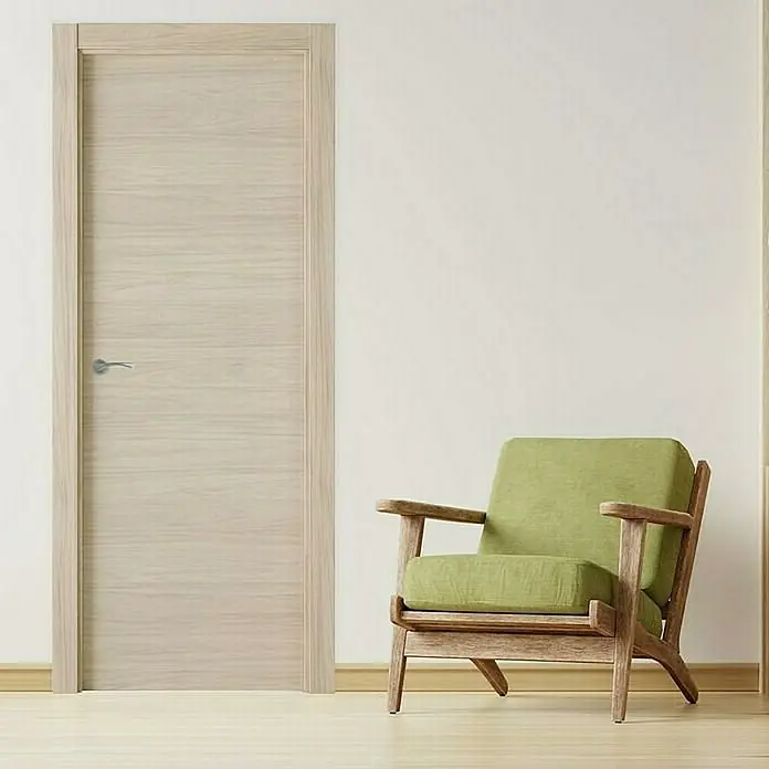 Pack puerta de interior Arizona - 82,5 x 203 cm, Derecha, Roble arena - Elegante puerta de madera clara con veta horizontal en un interior moderno, situada junto a un sillón verde.