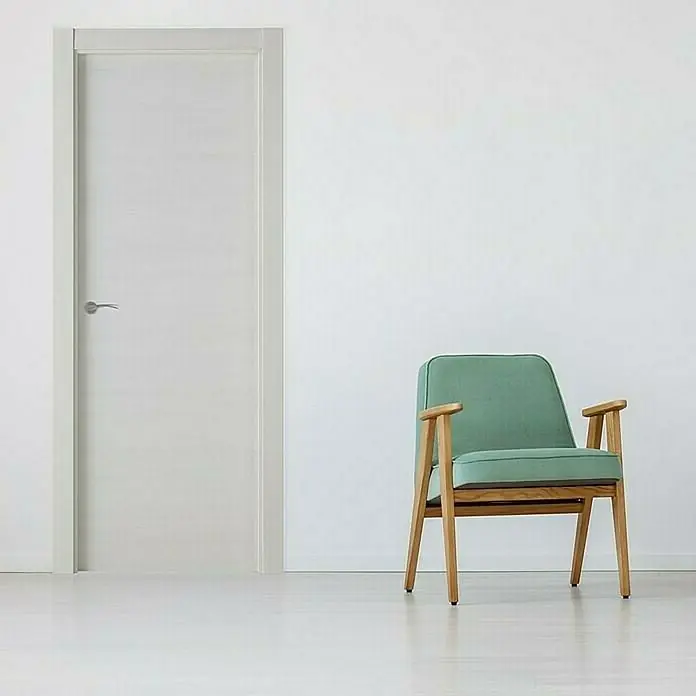 Pack puerta de interior Nebraska - 82,5 x 203 cm, Derecha, Gris claro - Una puerta interior blanca y moderna con un diseño sencillo, complementada con un sillón verde elegante que añade un toque tranquilo a la habitación.