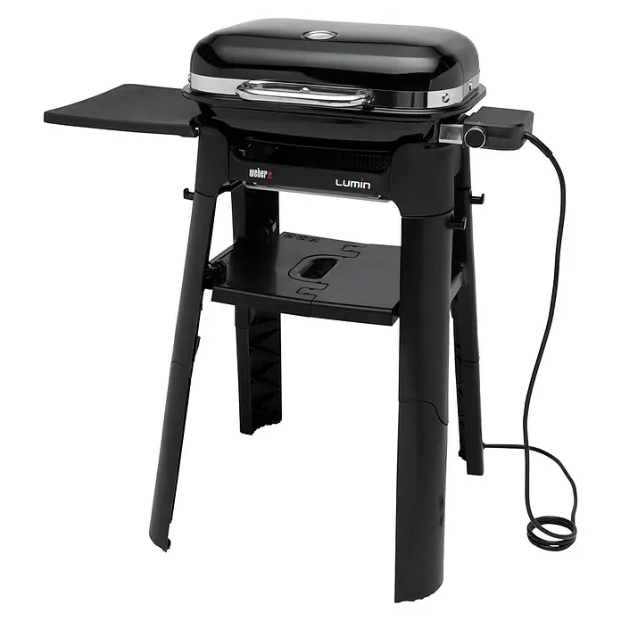 Weber Elektrogrill Lumin Compact - Grillfläche (B x T): 43 x 28 cm, 2.200 W, Standgrill - Abbildung eines schwarzen Weber Lumin Elektrogrills mit Seitenablage und Untergestell für den Außenbereich.