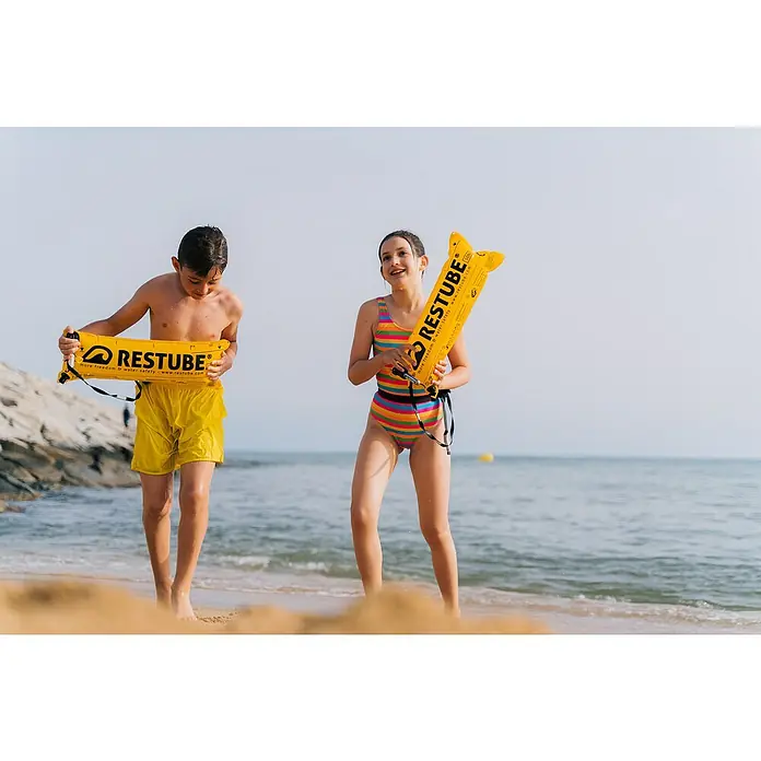 Restube Rettungsboje Restube beach - Geeignet für: 1 Person, Gelb - Zwei Kinder am Strand halten gelbe Restube-Schwimmhilfen. Die Restubes bieten mehr Freiheit und Sicherheit im Wasser.