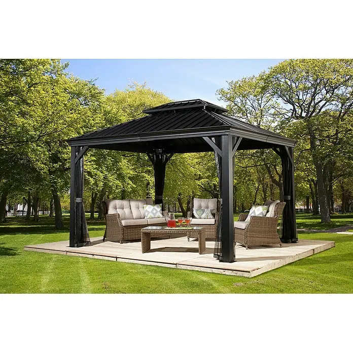 Sojag Standard-Pavillon Messina 10 x 12 - B x T: 363 x 298 cm, Farbe Gestell: Anthrazit, Aluminium - Elegante Gartenlaube mit komfortablen Sitzmöbeln und Couchtisch auf einer Holzplattform im Grünen.