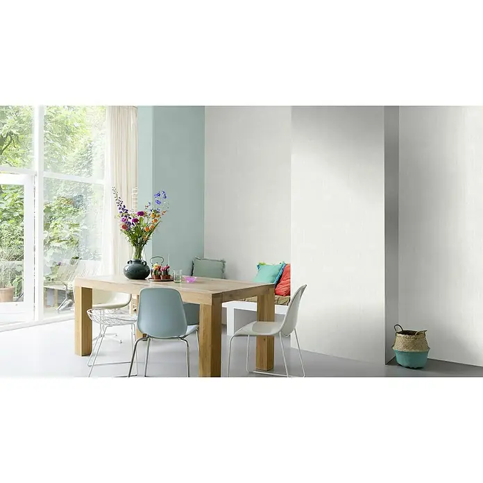Rasch Wallton Vliestapete Längsstruktur - Weiß, Uni, 10,05 x 0,53 m - Eine helle Essecke mit einem Holztisch, bunten Blumen in einer Vase und modernen Stühlen, die eine einladende Atmosphäre schaffen.